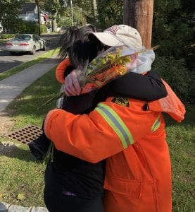 A crossing guard in Chatham, New Jersey, gets a hug and flowers from Sunnywoods Florist.