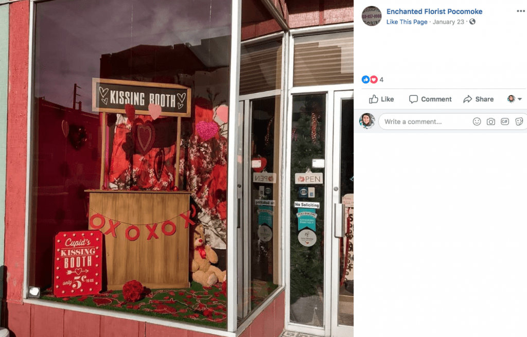 Lured by a window display with a kissing booth, couples in Pocomoke City, Maryland, have been stopping in Enchanted Florist to take a photo and place their Valentine’s Day order.